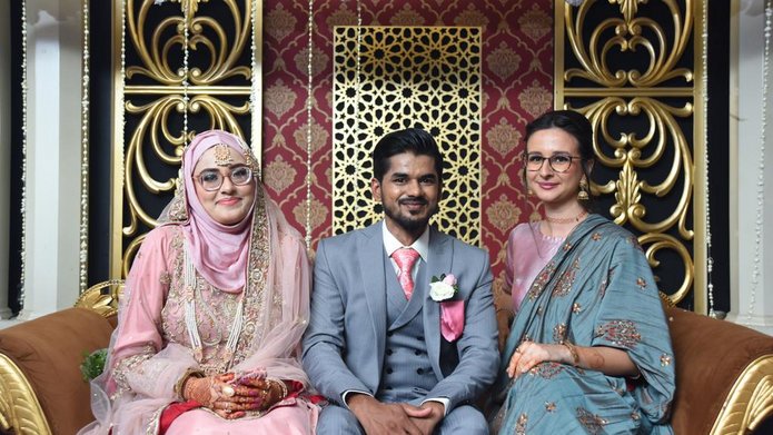 The student with the newly-weds during a wedding in Pakistan