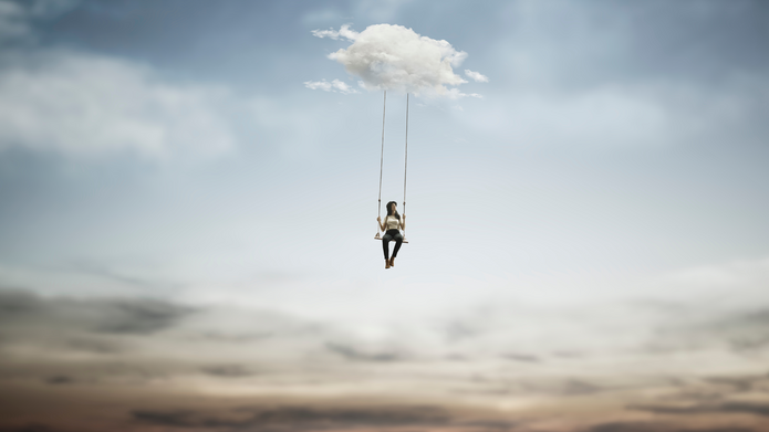A woman in a hat on a swing dangling from a cloud