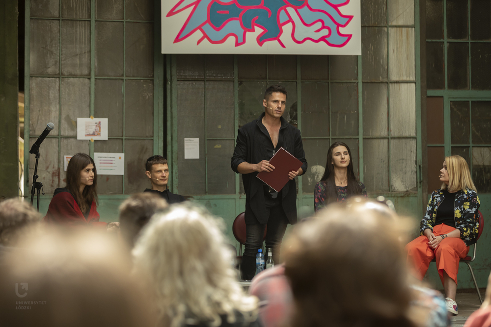 rozmówcy i prowadzący - trzy kobiety i dwóch mężczyzn na scenie w pofabrycznej scenerii rozmówcy i prowadzący - trzy kobiety i dwóch mężczyzn na scenie w pofabrycznej scenerii