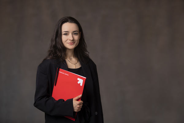 Studentka trzymający w ręku czerwoną papierową teczkę na dokumenty