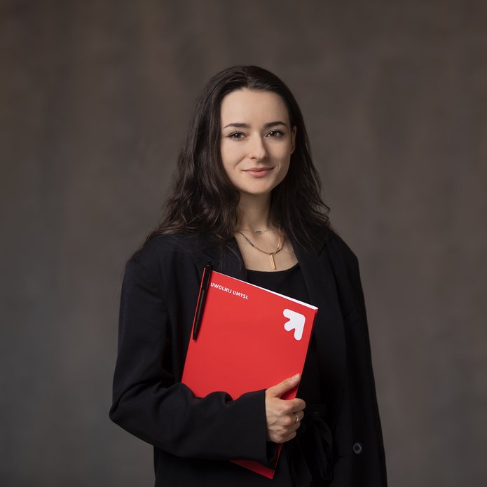 Studentka trzymająca w ręku czerwoną papierową teczkę na dokumenty