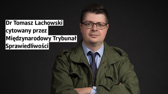 Mężczyzna w zielonej kurtce wojskowej i niebieskiej koszuli z krawatem