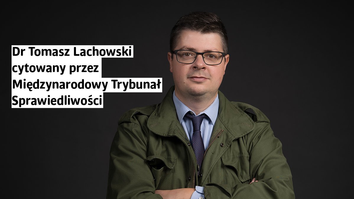 Mężczyzna w zielonej kurtce wojskowej i niebieskiej koszuli z krawatem