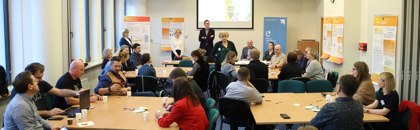 Grupa osób i dwoje prowadzących na sali wykładowej