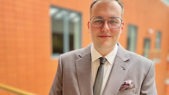 dr Paweł Łuczak na tle WZ UŁ