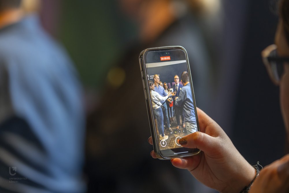 widok na telefon podczas nagrywania relacji na śniadaniu prasowym UŁ