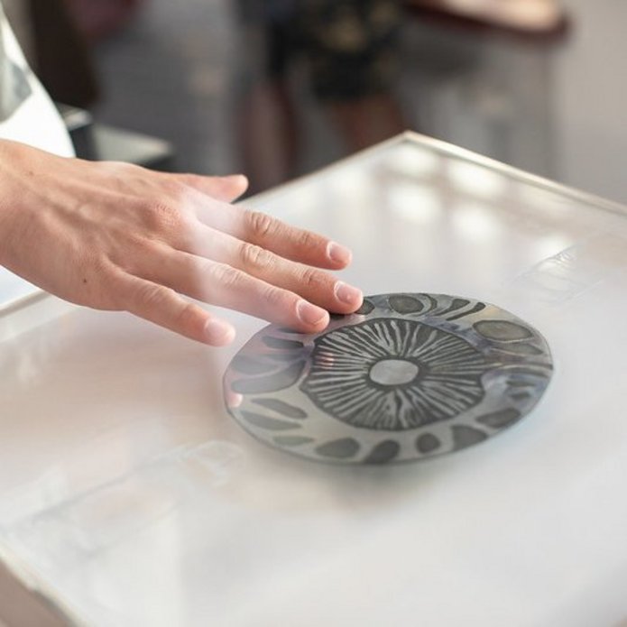 Ktoś dotyka dłonią pracę plastyczną