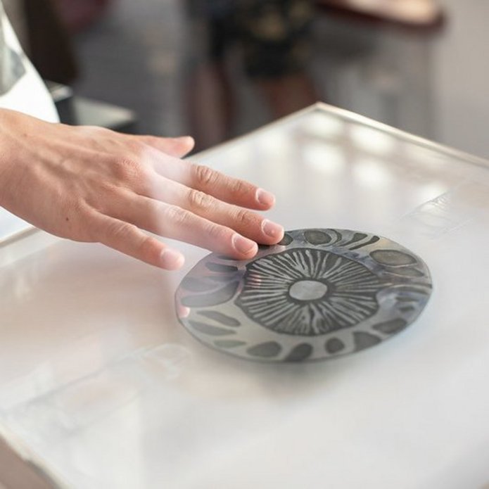 Ktoś dotyka dłonią pracę plastyczną