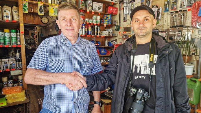 Na zdjęciu widać dwóch mężczyzn stojącyh w sklepie z artykułami motoryzacyjnymi.