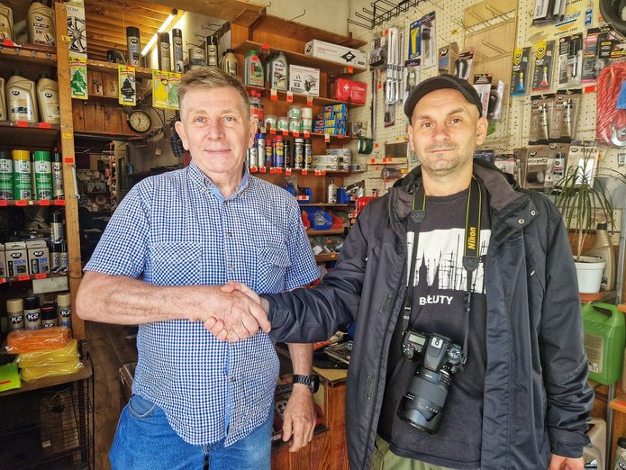 Na zdjęciu widać dwóch mężczyzn stojącyh w sklepie z artykułami motoryzacyjnymi.