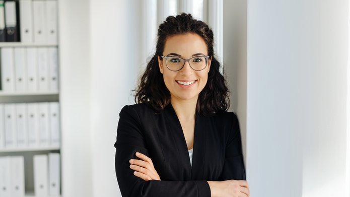 kobieta w okularach przed regałem biurowym