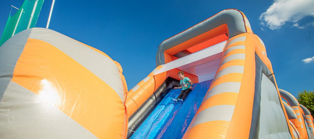 chłopczyk zjeżdżający na dmuchańcu