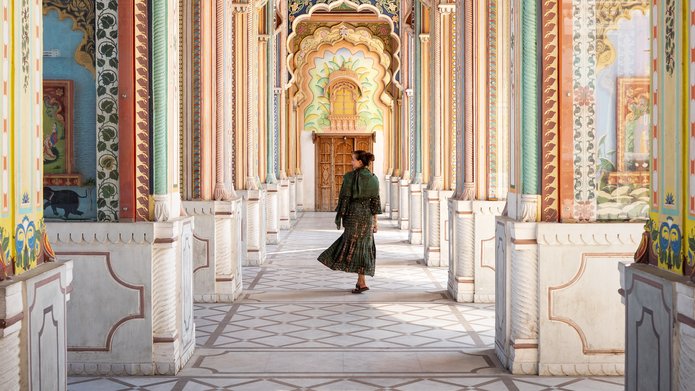 A woman walking through the arcades of an Indian building