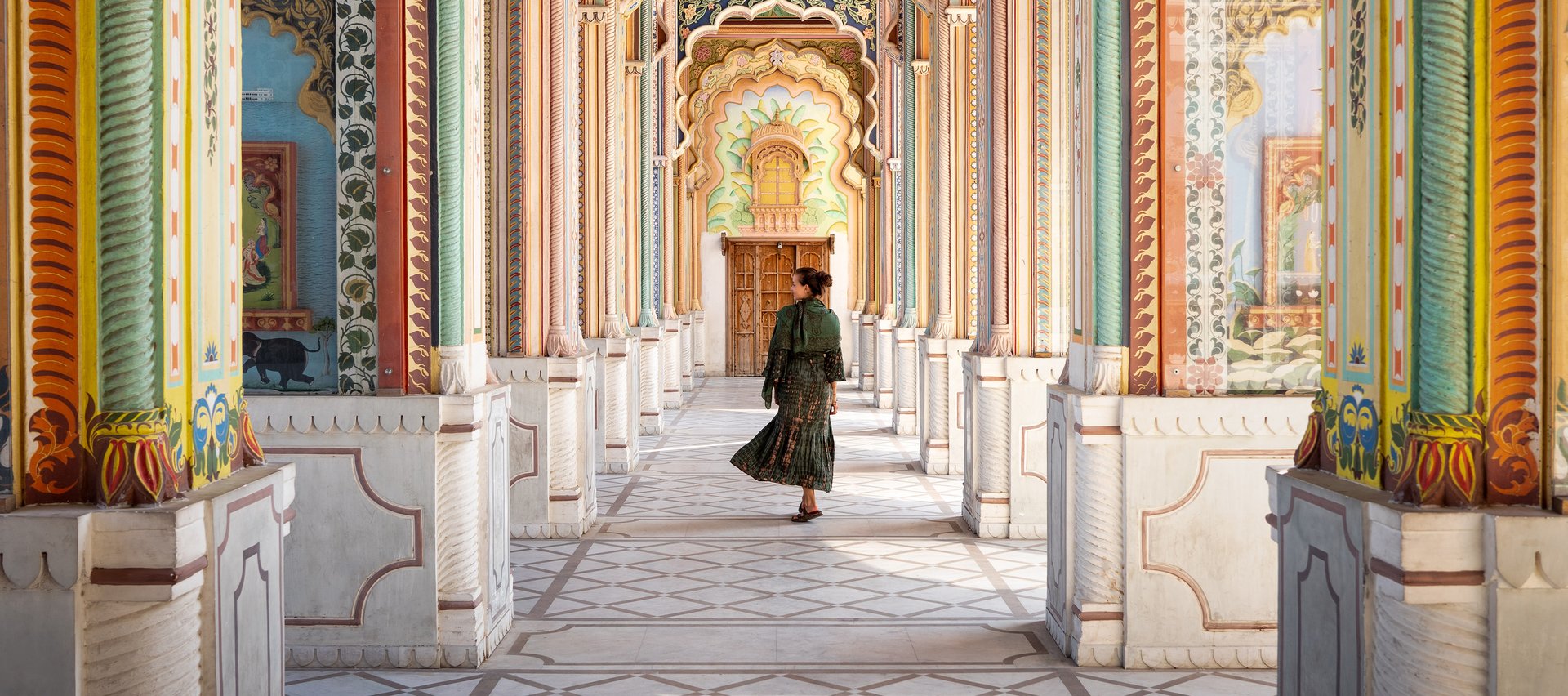 A woman walking through the arcades of an Indian building