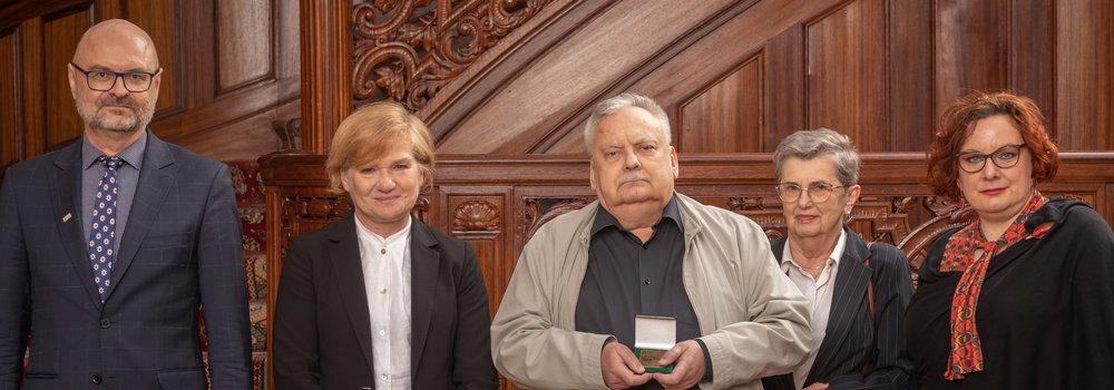 Andrzej Sapkowski i uczestnicy wydarzenia po wręczeniu medalu