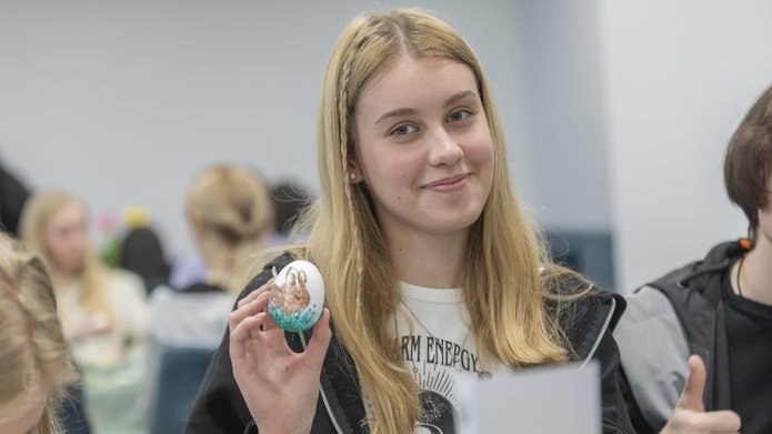 studentka trzymająca pisankę, którą wcześniej sama przygotowała