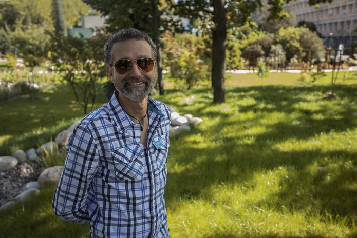 a smiling prof. Kok wearing sunglasses and standing in front of the Faculty building