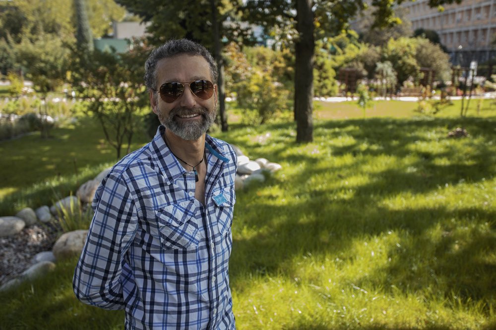 a smiling prof. Kok wearing sunglasses and standing in front of the Faculty building
