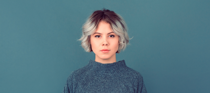 młoda kobieta z krótkimi włosami na niebieskim tle