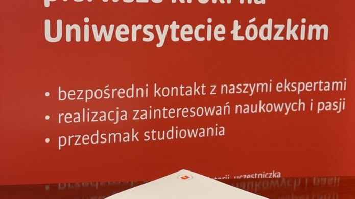 Na tle banneru projektu Zdolny uczeń świetny student zrobione zdjęcie białej teczki