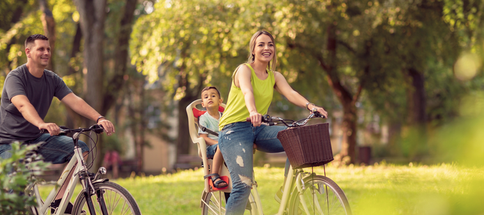 cyclists in the park: a woman, a man and a child