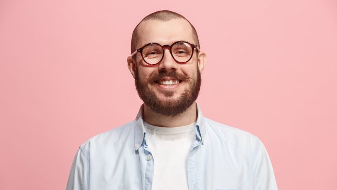 Uśmiechnięty młody mężczyzna w okularach.