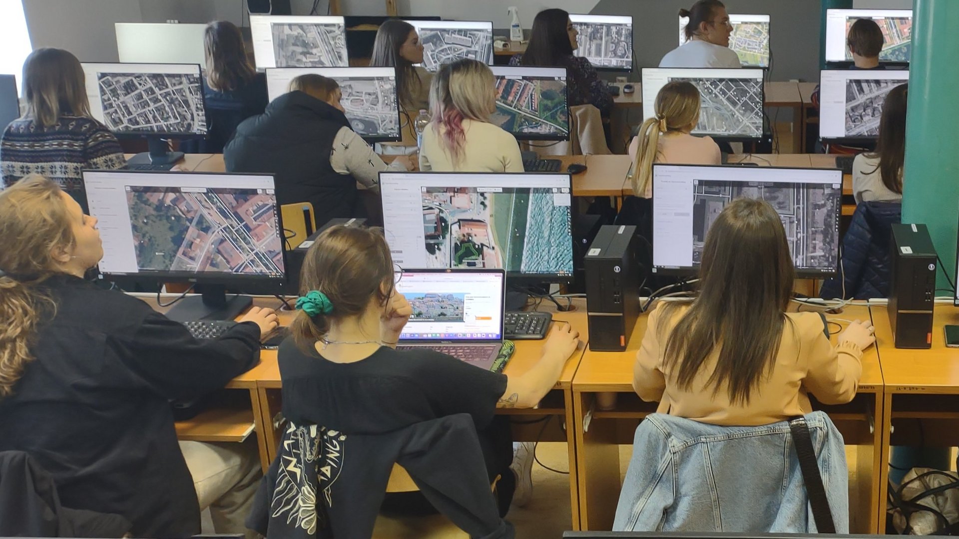 Sylwetki osób siedzących przy komputerach