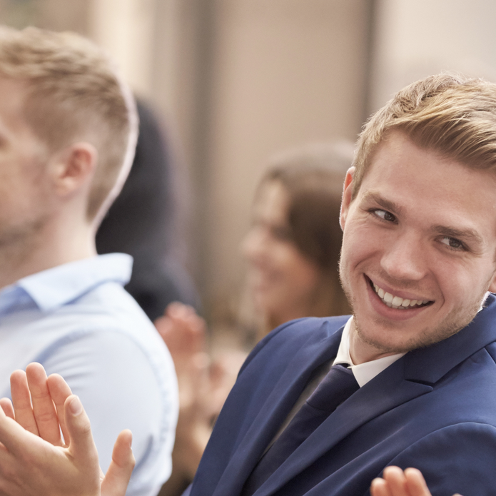 Uśmiechnięty młody mężczyzna bijący brawo