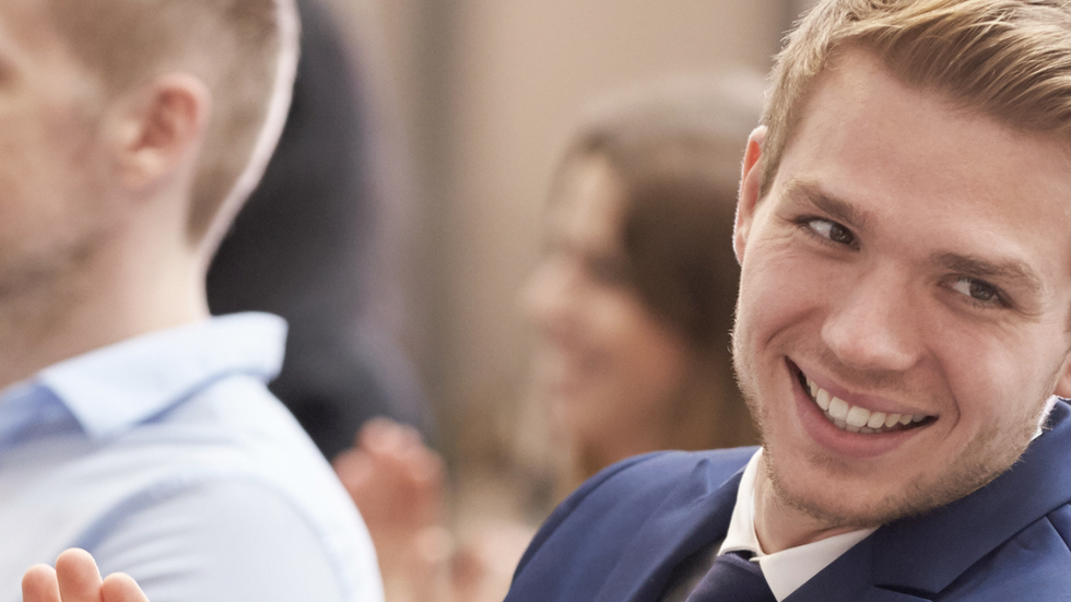 Uśmiechnięty młody mężczyzna bijący brawo