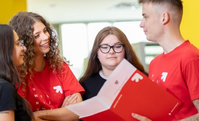 4 studentów rozmawia na korytarzu