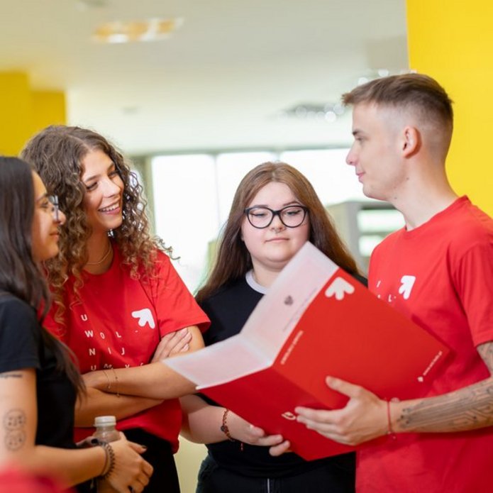 4 studentów rozmawia na korytarzu