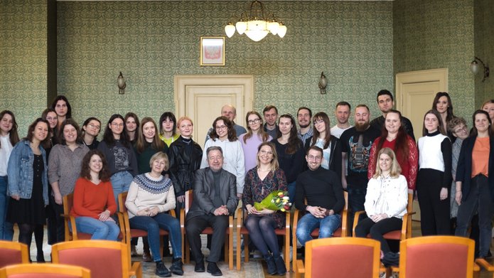 zdjęcie grupowe prof. Kończala z uczestnikami warsztatów w Pałacu Biedermanna