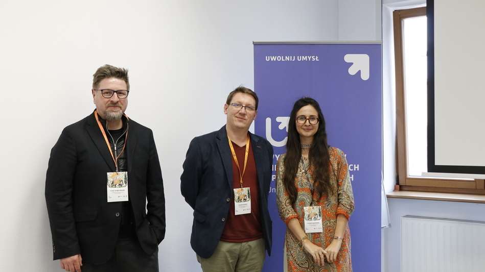 speakers against the background of a banner of the Faculty of International and Political Studies