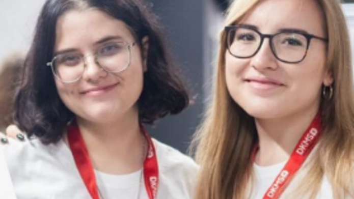 2 młode kobiety w białych koszulkach z napisem Helpers' Generation