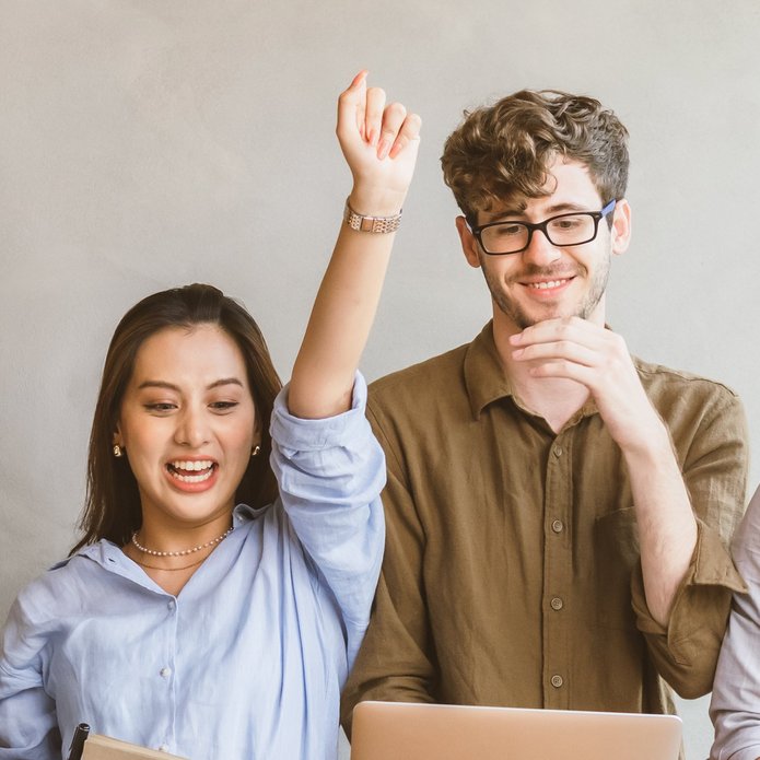 a young woman with her arms raised and a young smiling man