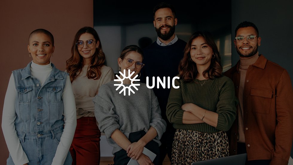 stojąca grupa ludzi z logo unic