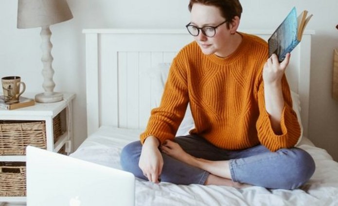 Osoba ucząca się na łóżku przed komputerem