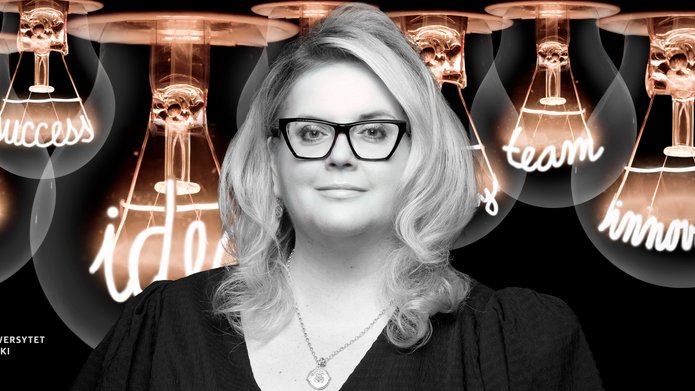 Dr Kinga Stopczyńska against the background of large abstract light bulbs with illuminated inspirational words in place of the filaments