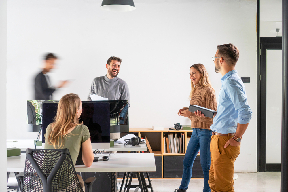 Smiling young people talking in the office.