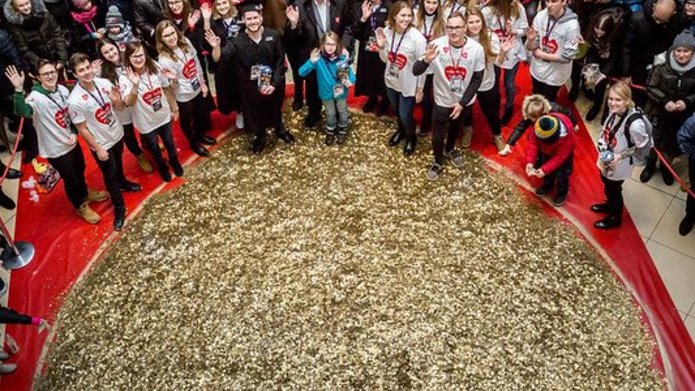  The University of Lodz students from the Student Science Club Inwestor standing with the University of Lodz authorities next to a heart made of gold coins