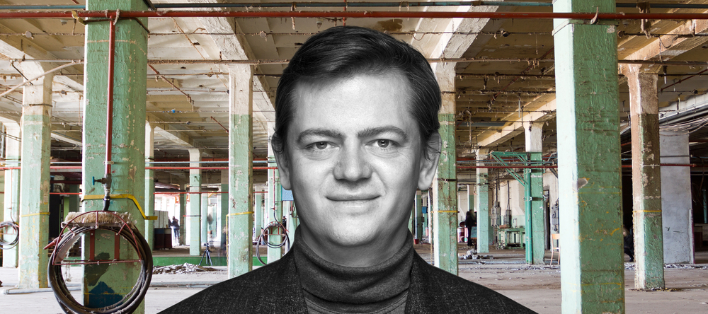 Dr. Marcin Szymański with the interior of an abandoned textile factory in the background
