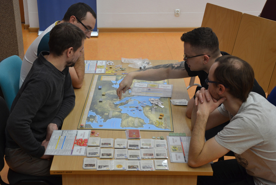 osoby uczestniczące w grze siedzące wokół stołu z grą osoby uczestniczące w grze siedzące wokół stołu z grą