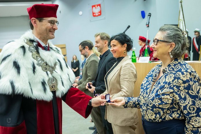 Rector of the University of Lodz presenting a distinction to a member of staff