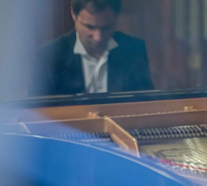 Mężczyzna w marynarce przy fortepianie