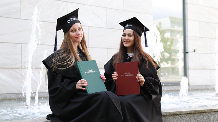 Absolwentki trzymające prace magisterskie