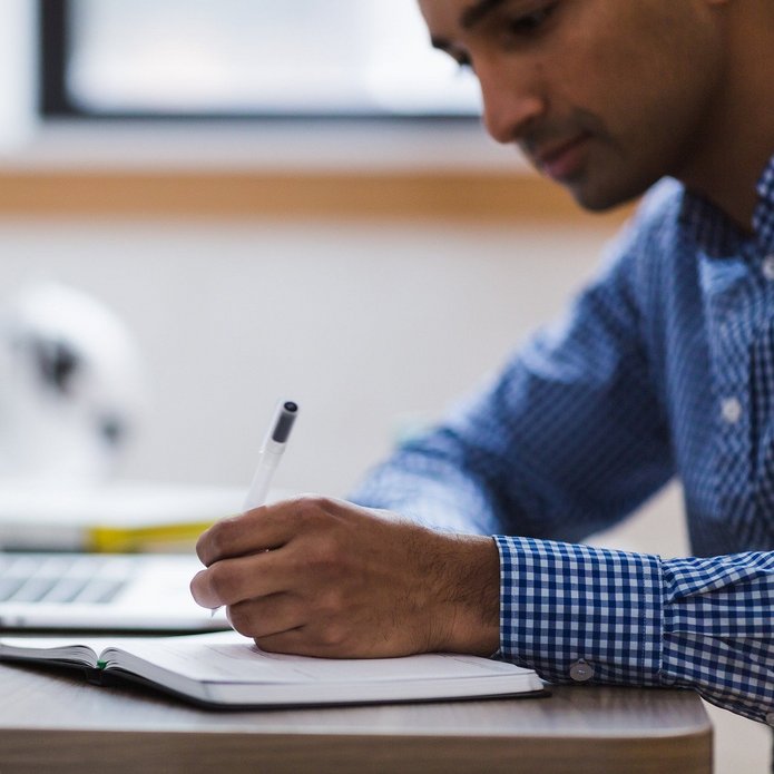 Mężczyzna sporządza notatki, zdjęcie poglądowe.