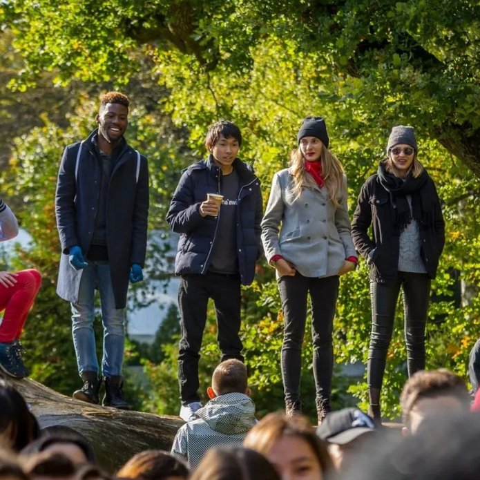 A group of young people against a background of green trees