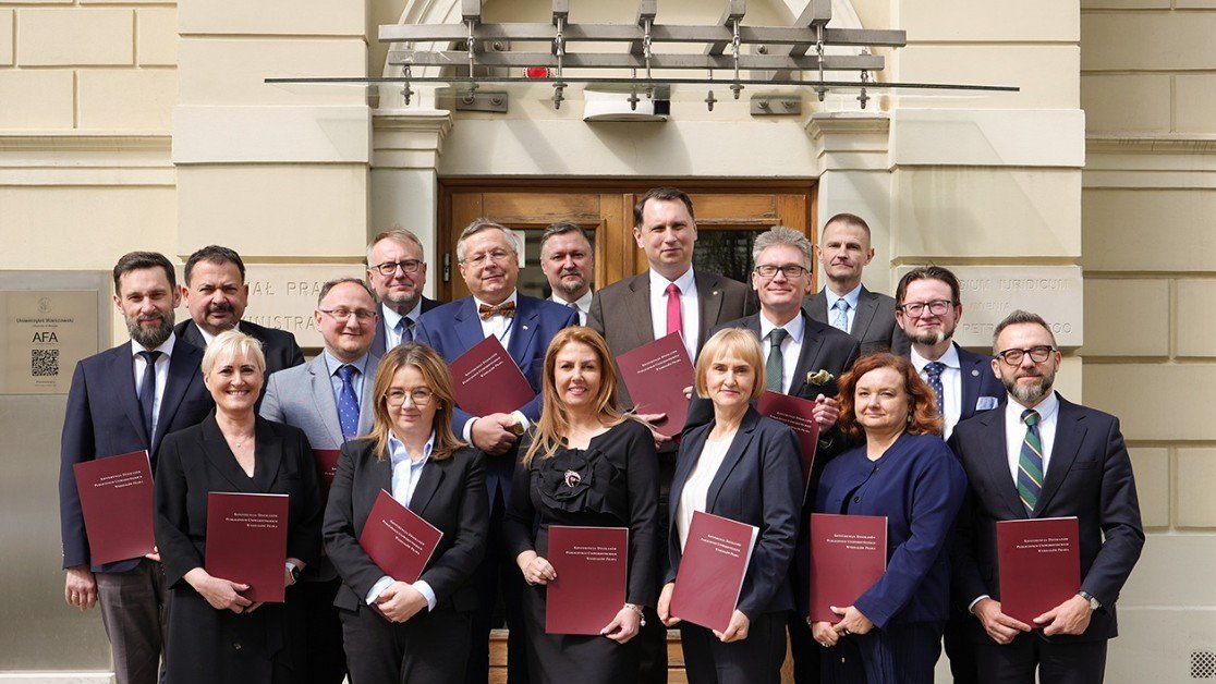 Grupa ludzi trzymająca podpisane porozumienia