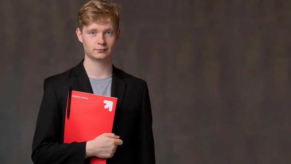 A UniLodz students holds a red folder.