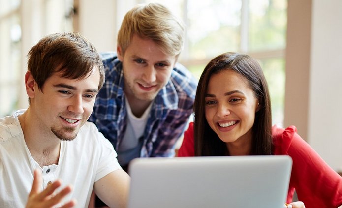 Trzy uśmiechnięte osoby patrzą w ekran, kobieta, dwóch mężczyzn